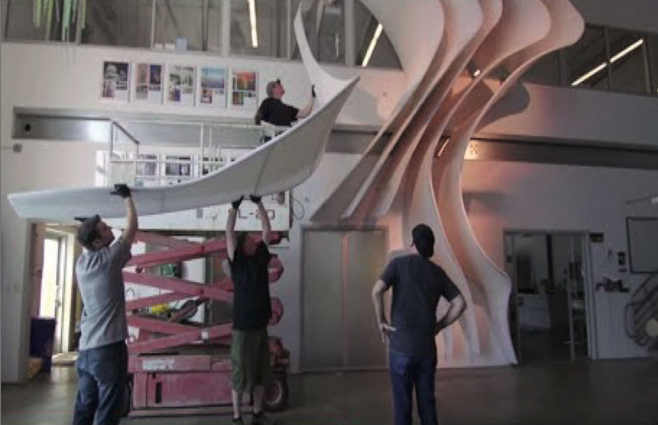 Production team assembling bent tubing for The Canyon at SLC Airport